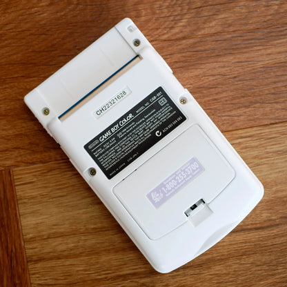 Back view of a Game Boy Color on a wooden surface robot retro