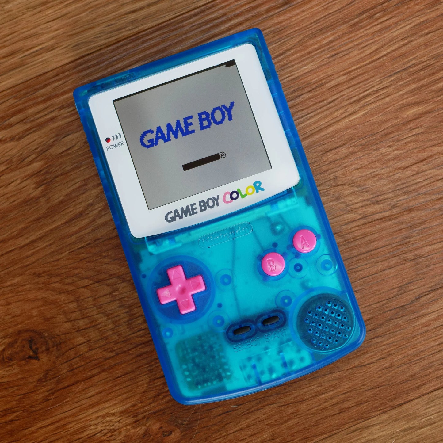 Blue Game Boy Color on a wooden surface robot retro