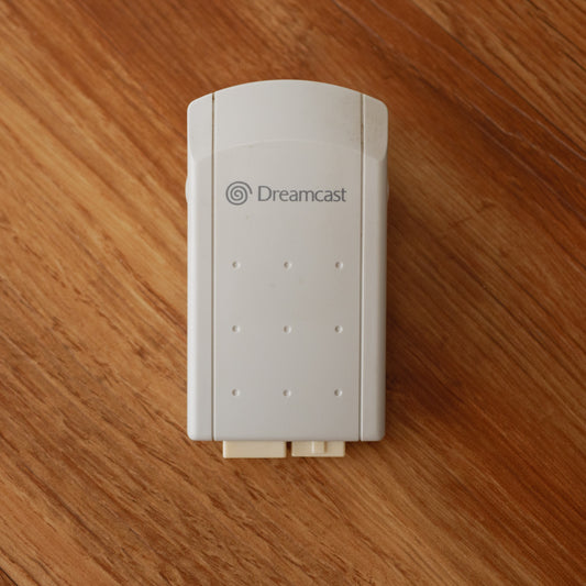 White Dreamcast Rumble Pack on a wooden surface